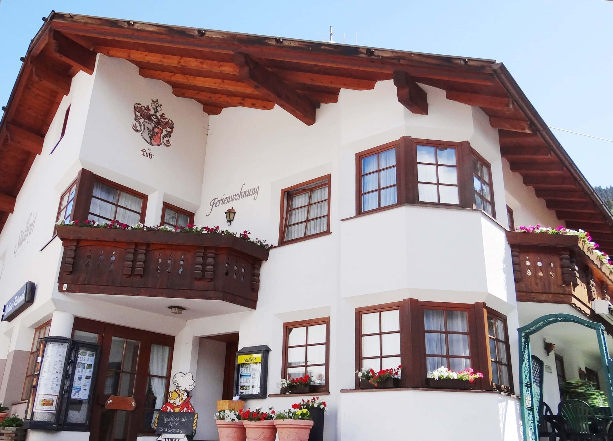 Das Stadlwirt-Haus in Nauders, mit Holzbalkon und Blumenkästen